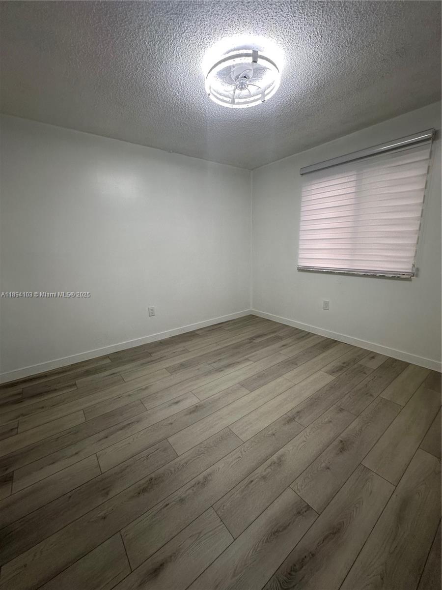 1852 Southwest 7th Street, Unit 109 Miami, FL 33135 - Photo 10 of 21 an empty room with wooden floor and windows