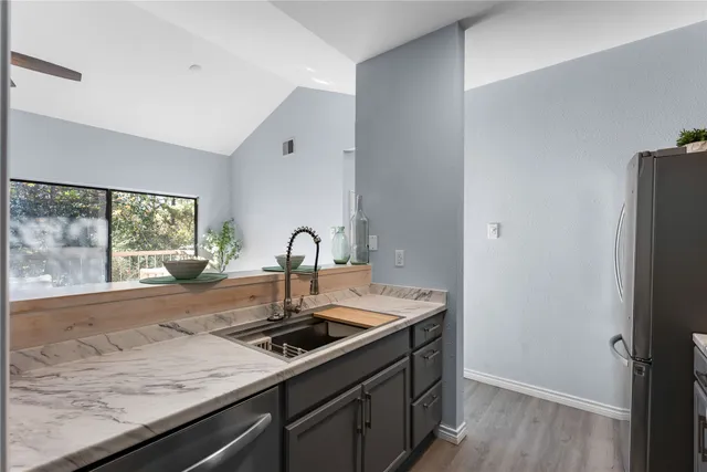 a kitchen with a sink and wooden floor