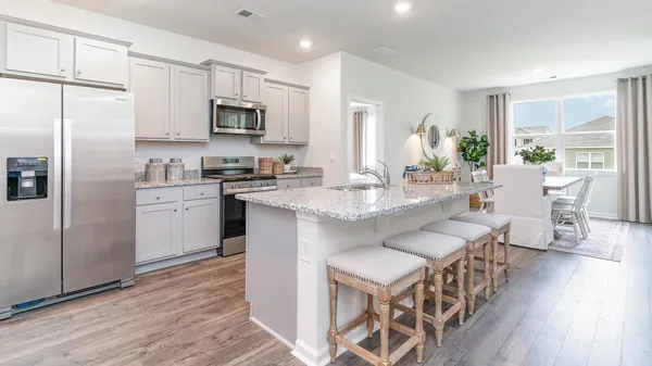 a kitchen with granite countertop a sink stove and cabinets