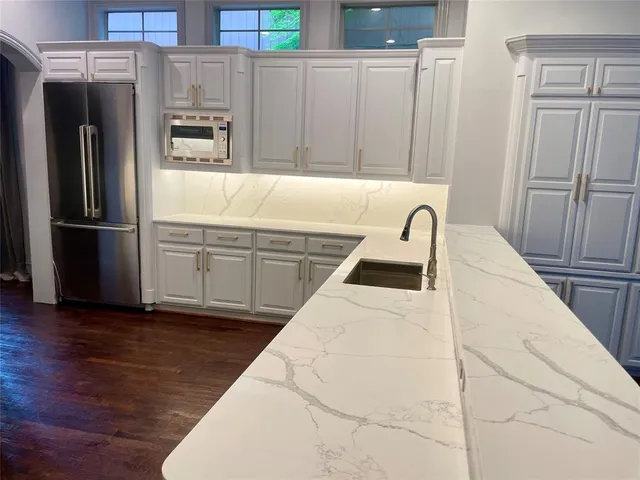 a kitchen with granite countertop a refrigerator and a sink