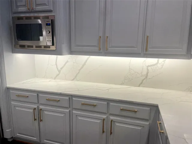 a close view of a sink a cabinet and a flat screen tv