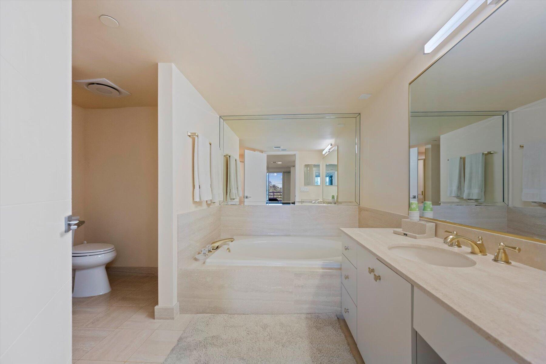 4101 North Ocean Boulevard, Unit 308 Boca Raton, FL 33431 - Photo 13 of 23 a spacious bathroom with a bathtub sink mirror and toilet