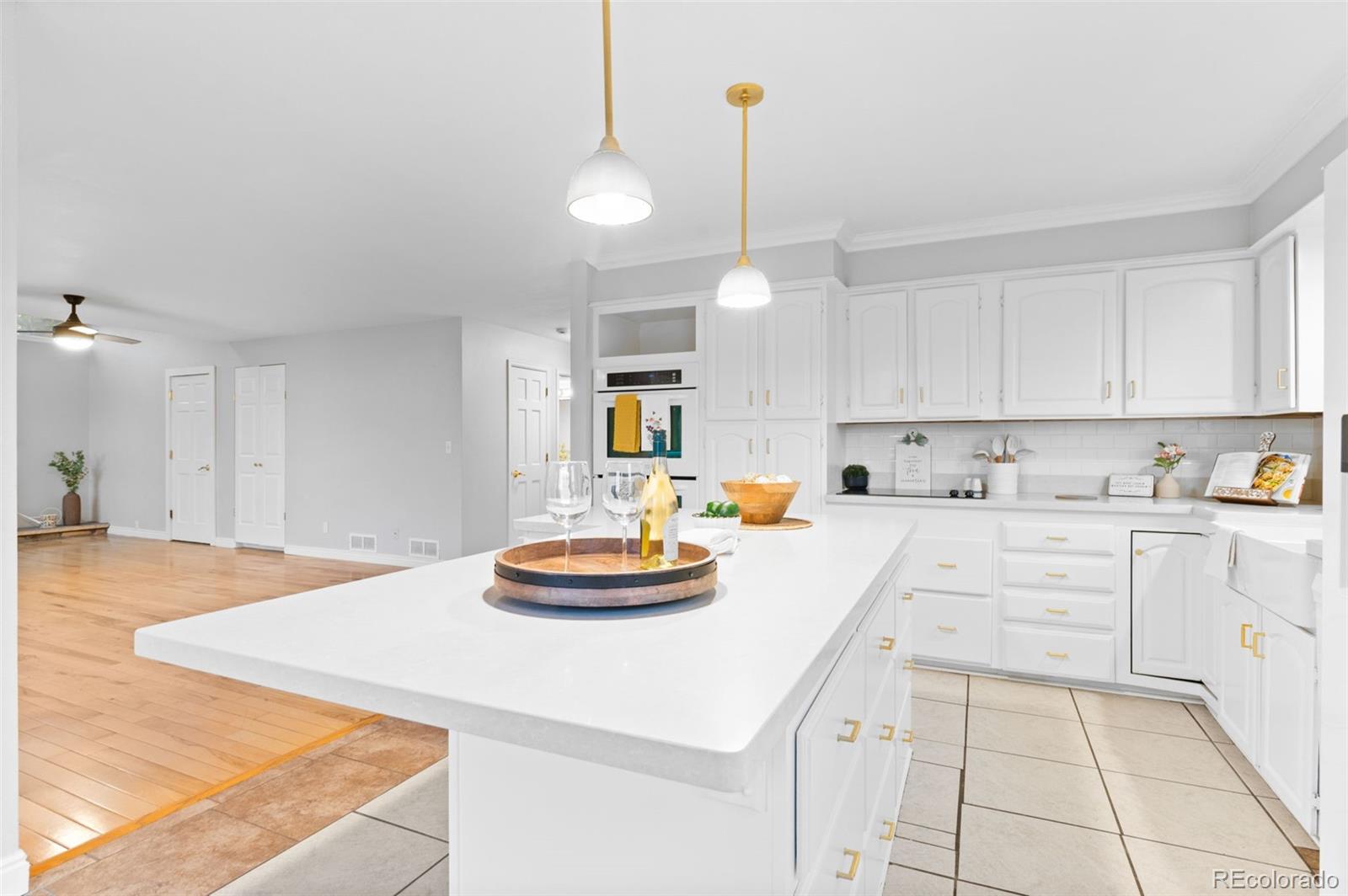 8385 Sweet Water Road Lone Tree, CO 80124 - Photo 13 of 50 a kitchen with a sink a stove and chairs