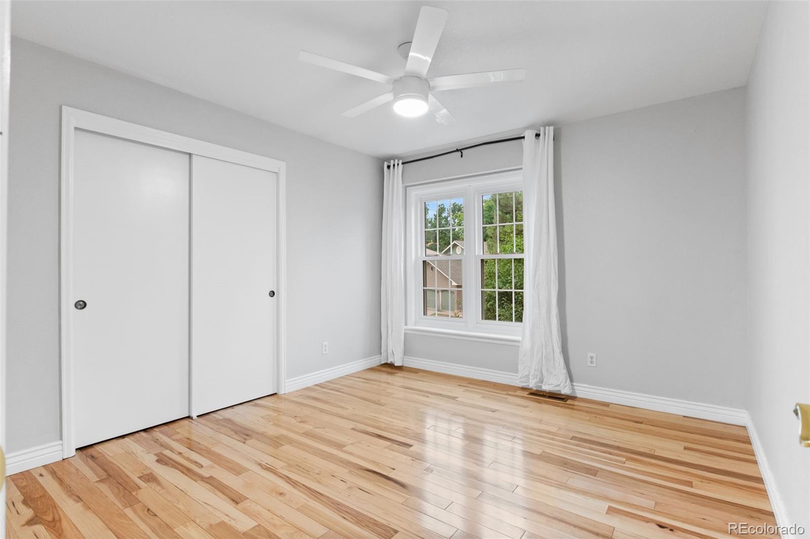 8385 Sweet Water Road Lone Tree, CO 80124 - Photo 30 of 50 a view of empty room with wooden floor and fan