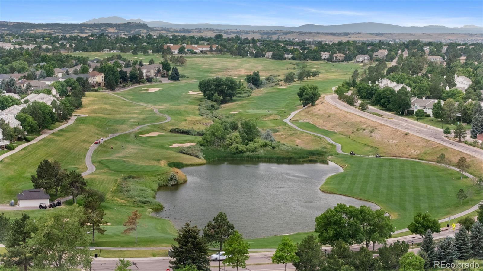 8385 Sweet Water Road Lone Tree, CO 80124 - Photo 41 of 50 an aerial view of green landscape with trees houses and lake view