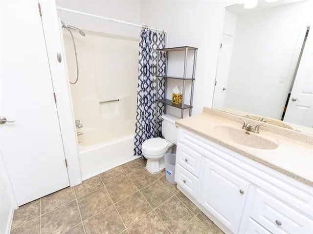 a bathroom with a sink toilet double vanity and shower