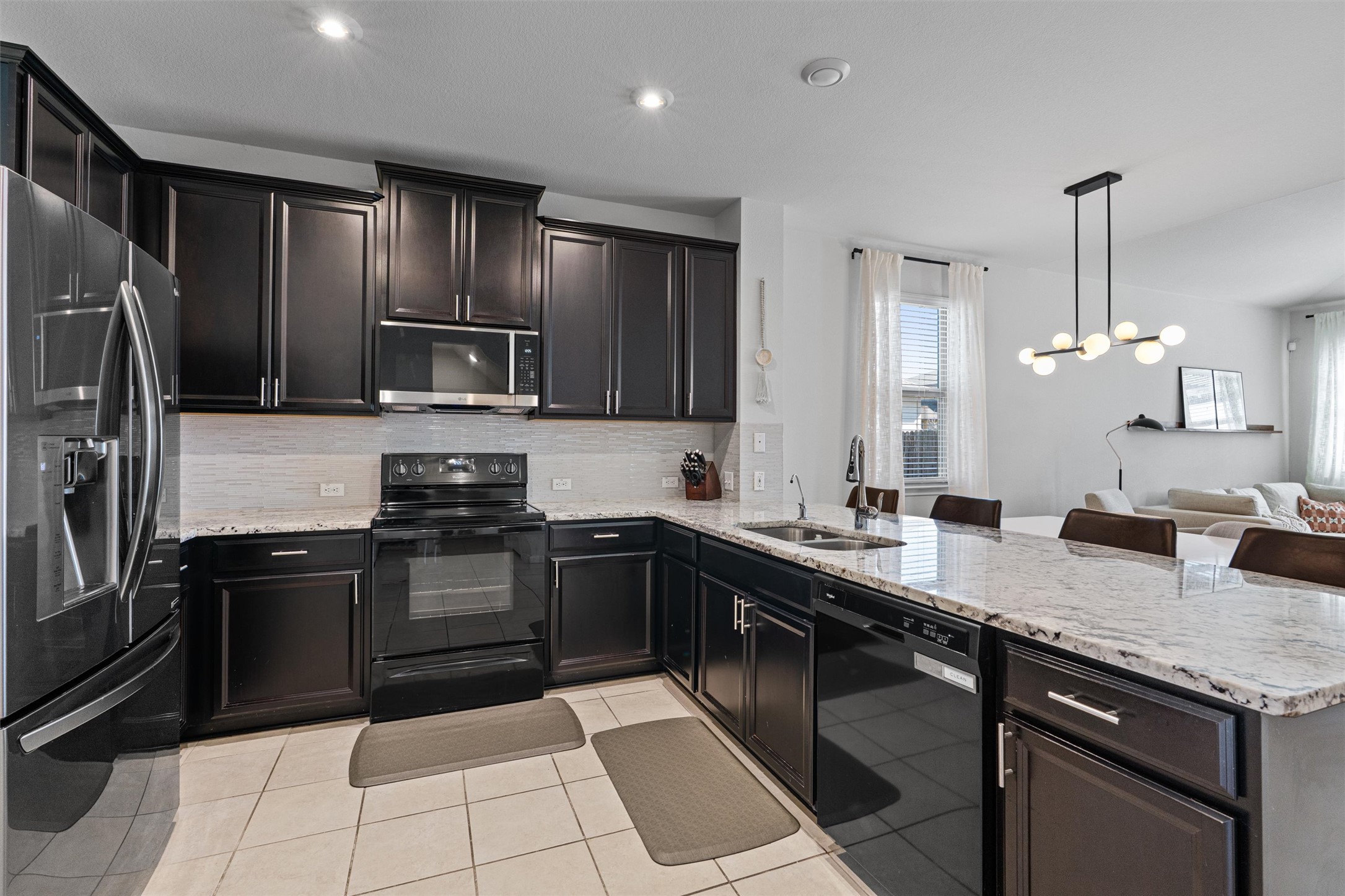 137 Red Sun Drive Kyle, TX 78640 - Photo 4 of 38 a kitchen with stainless steel appliances granite countertop a sink stove and refrigerator