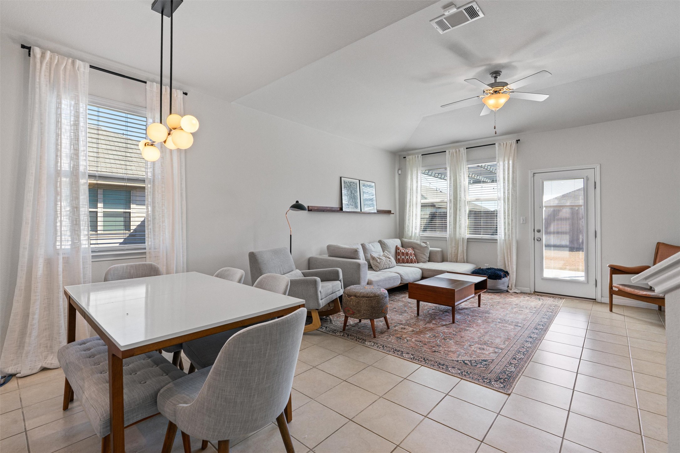 137 Red Sun Drive Kyle, TX 78640 - Photo 7 of 38 a living room with furniture a dining table and a chandelier
