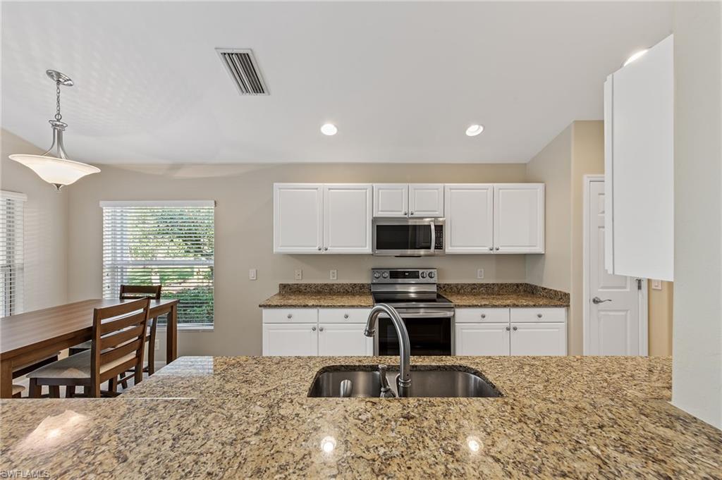 9996 Horse Creek Road Fort Myers, FL 33913 - Photo 18 of 44 a kitchen with stainless steel appliances granite countertop a stove a sink a refrigerator and a microwave