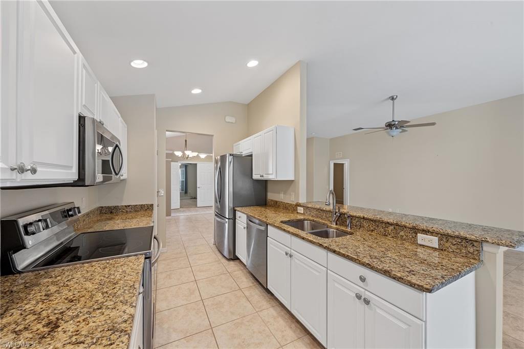 9996 Horse Creek Road Fort Myers, FL 33913 - Photo 19 of 44 a kitchen with stainless steel appliances granite countertop a sink stove and refrigerator