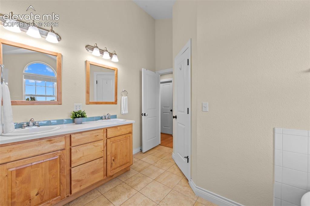 16540 Mesquite Road Peyton, CO 80831 - Photo 30 of 50 a spacious bathroom with a double vanity sink a mirror and a bathtub