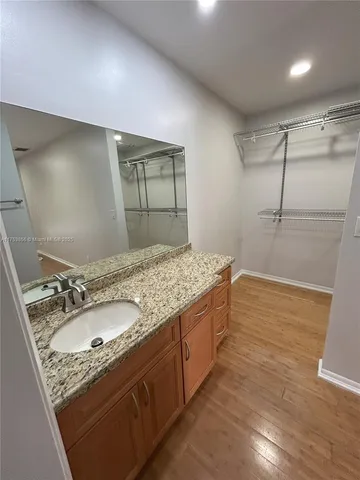 a bathroom with a granite countertop sink a mirror and shower
