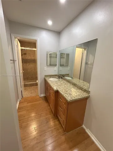 a spacious bathroom with a granite countertop sink and a mirror