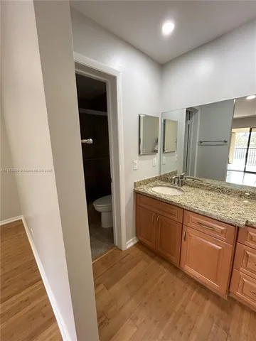 a spacious bathroom with a granite countertop sink and a mirror