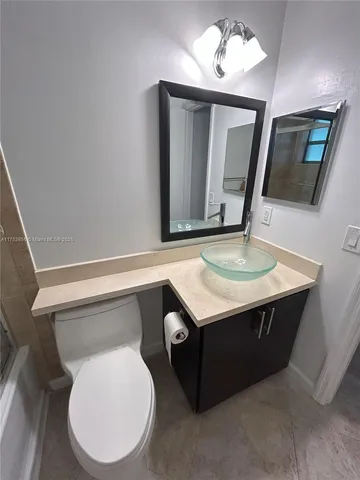 a bathroom with a toilet sink and mirror