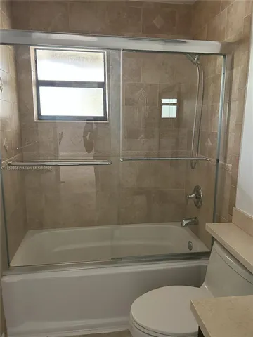 a bathroom with a toilet and a bath tub