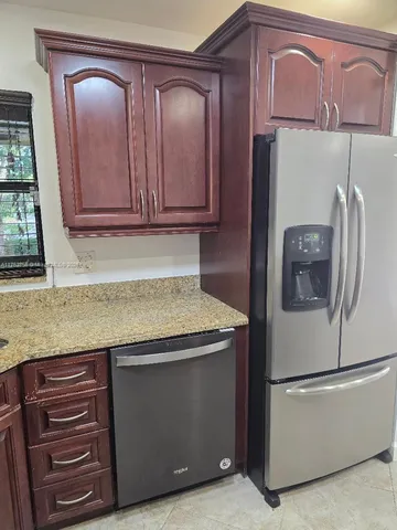 a kitchen with granite countertop cabinets and refrigerator