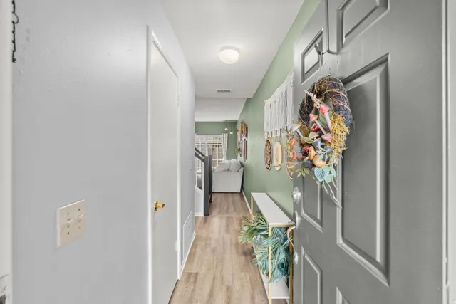 a view of a hallway with bathroom and wooden floor