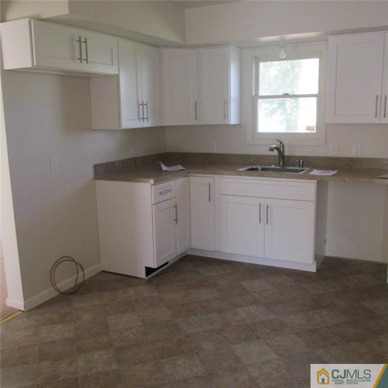 738 New Dover Road Edison, NJ 08820 - Photo 3 of 9 a kitchen with granite countertop white cabinets sink and window