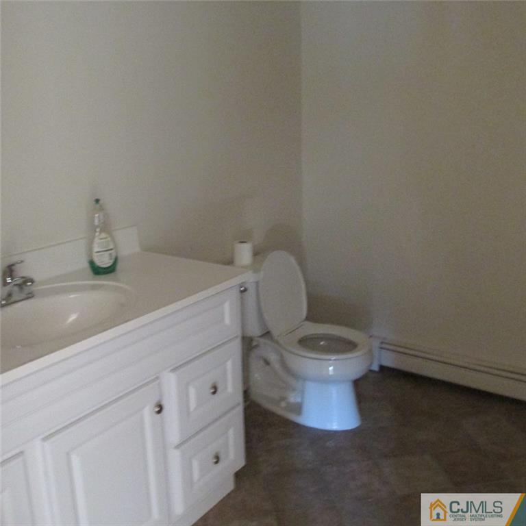 738 New Dover Road Edison, NJ 08820 - Photo 4 of 9 a bathroom with a toilet a sink and mirror