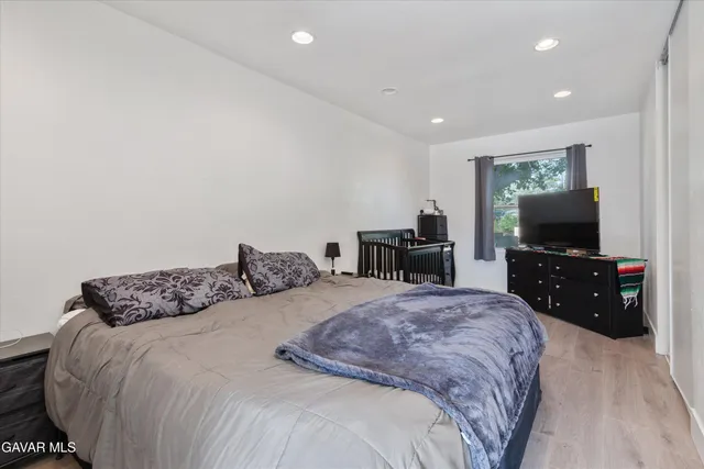 a bedroom with a bed and a flat screen tv