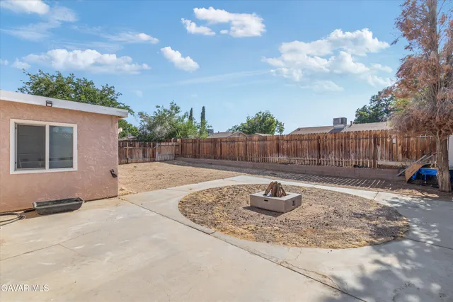 a backyard of a house with table and chairs