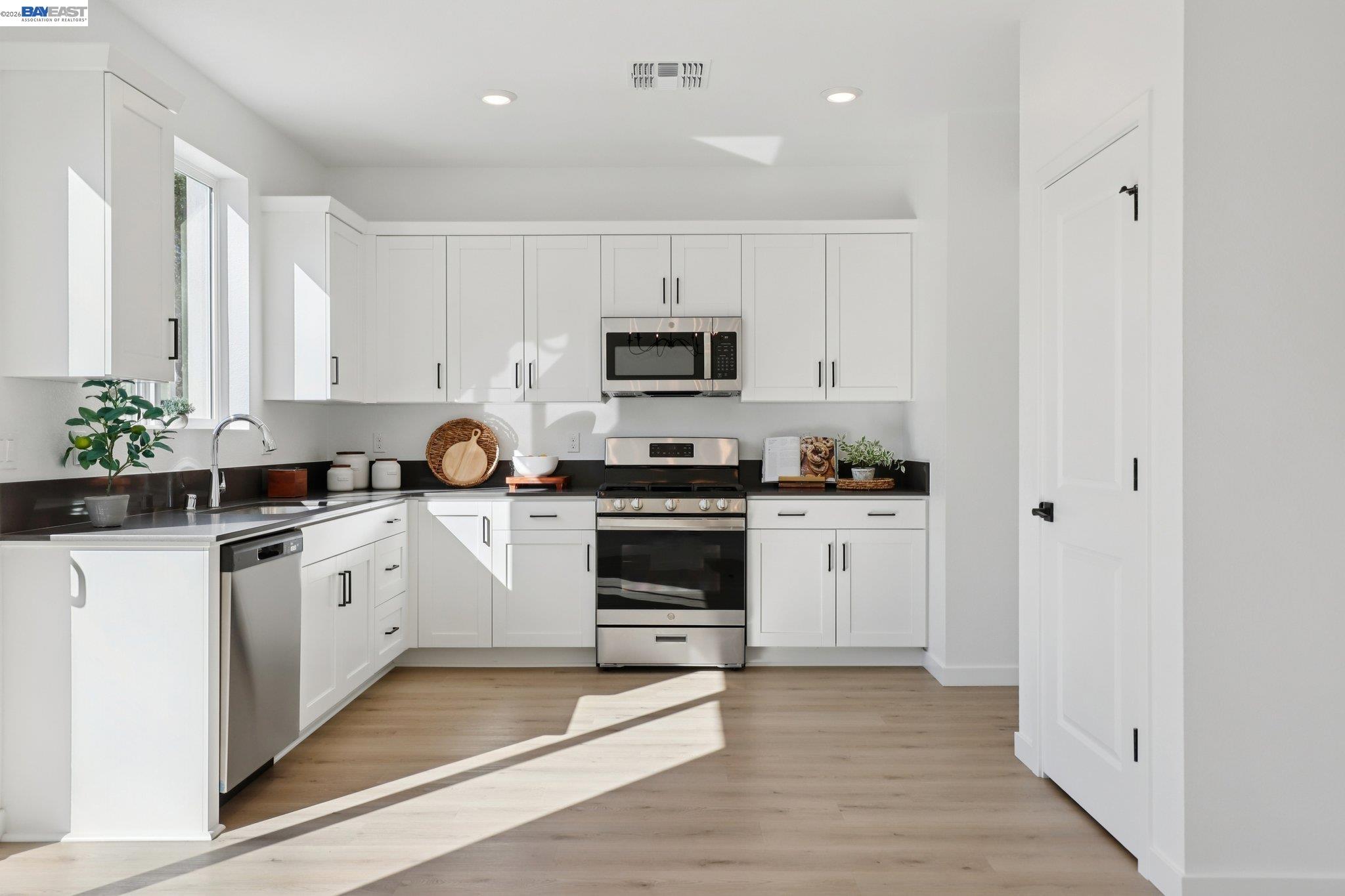 856 Pecan Tree Lane Galt, CA 95632 - Photo 11 of 30 a white kitchen with stainless steel appliances granite countertop a stove a sink and a microwave