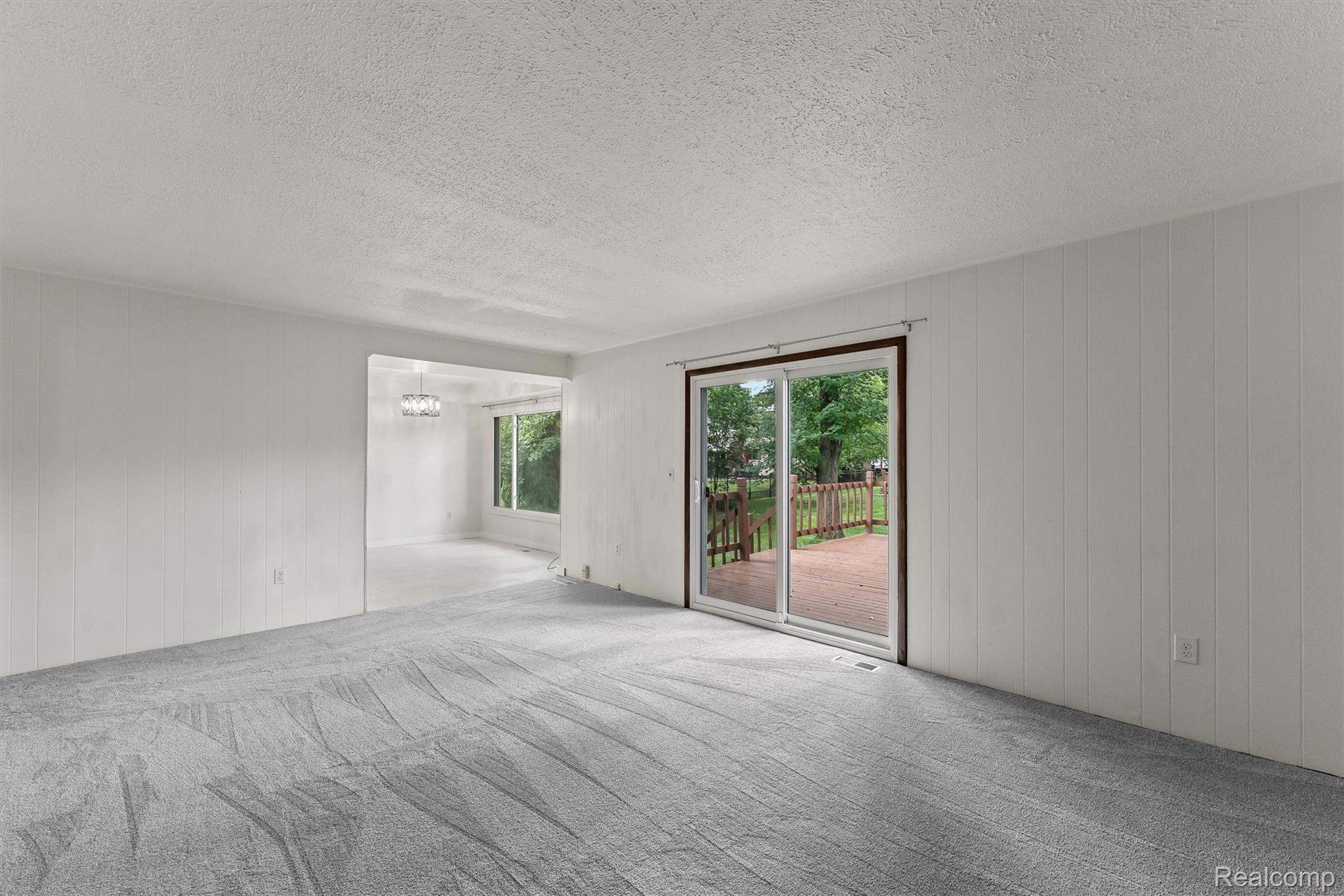 2118 Rutgers Drive Troy, MI 48085 - Photo 14 of 39 Expansive living area with grey patterned carpet and white vertical paneling