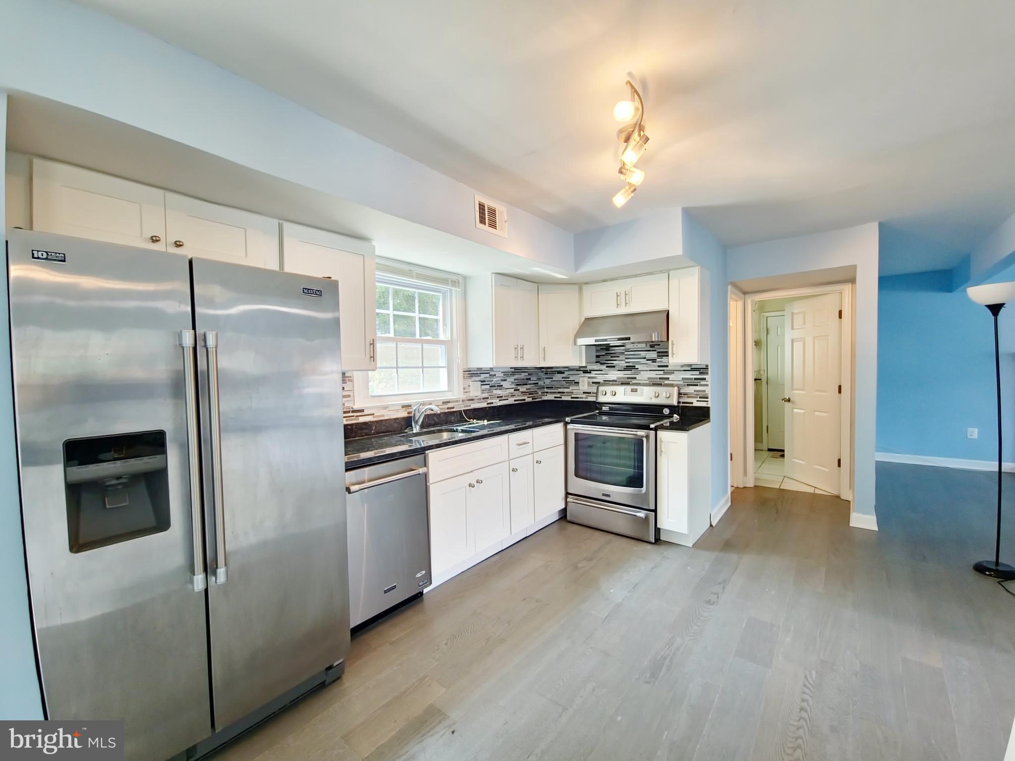 6808 Ben Franklin Road Springfield, VA 22150 - Photo 29 of 34 a kitchen with stainless steel appliances a refrigerator sink and cabinets