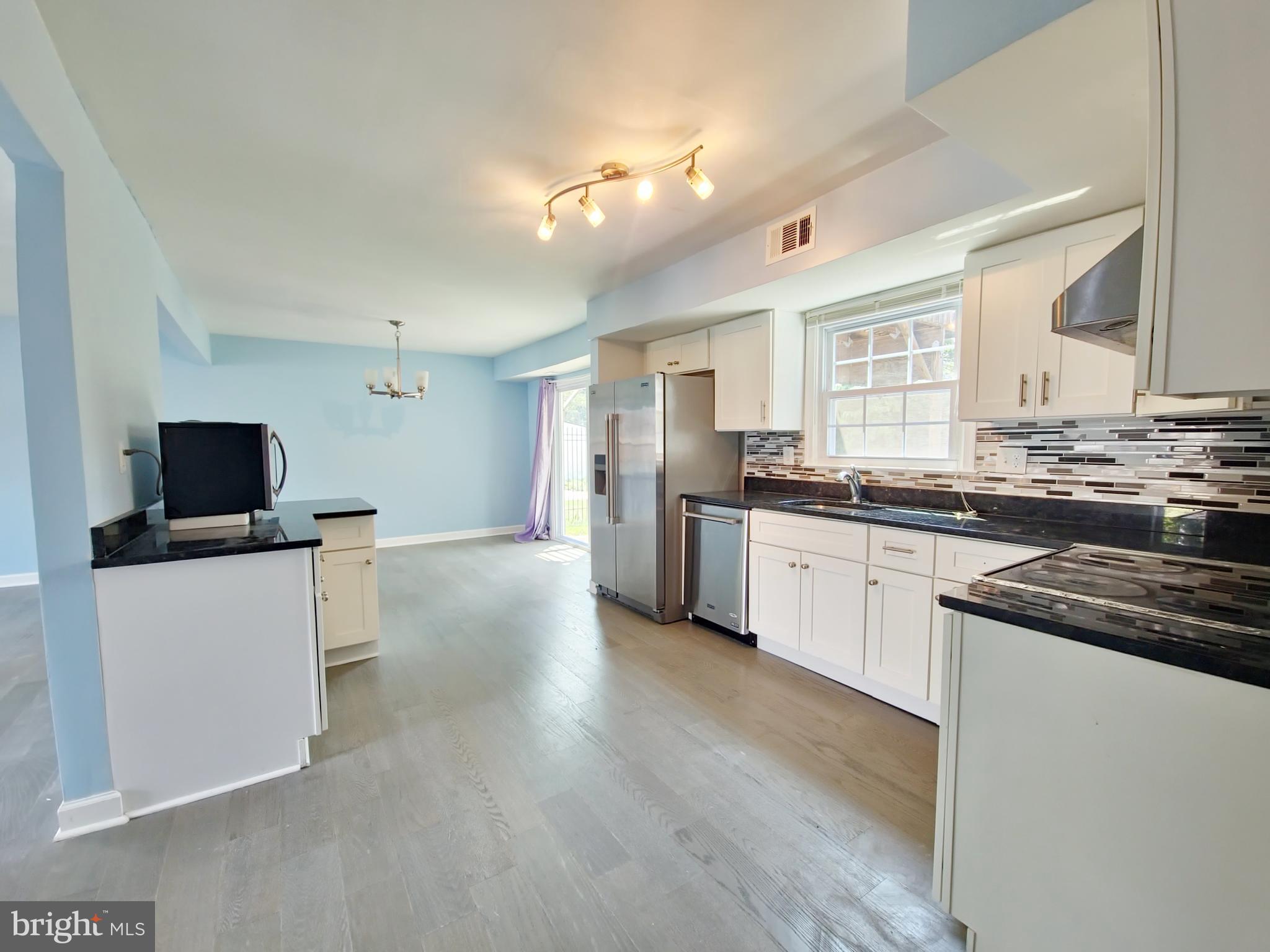 6808 Ben Franklin Road Springfield, VA 22150 - Photo 30 of 34 a kitchen with stainless steel appliances granite countertop a sink stove and refrigerator