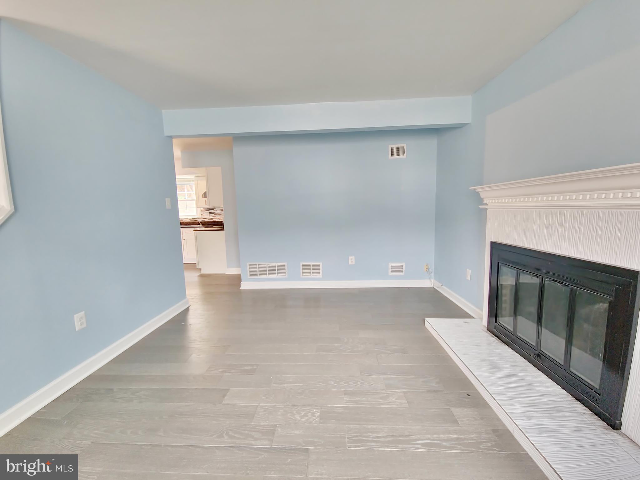 6808 Ben Franklin Road Springfield, VA 22150 - Photo 5 of 34 a view of empty room with wooden floor and fireplace