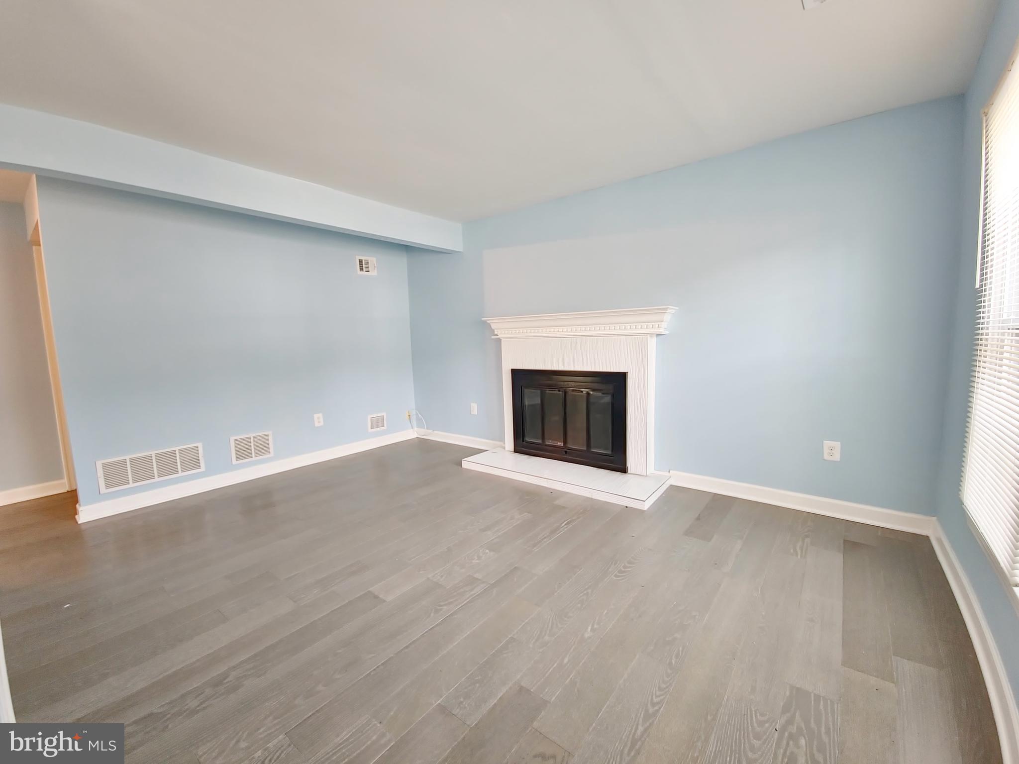 6808 Ben Franklin Road Springfield, VA 22150 - Photo 8 of 34 a view of empty room with wooden floor and fireplace