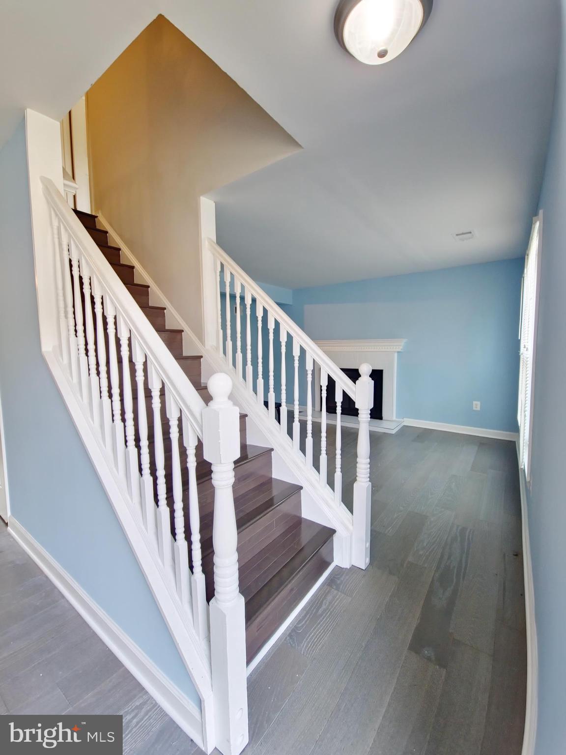 6808 Ben Franklin Road Springfield, VA 22150 - Photo 9 of 34 a view of staircase with white walls and wooden floor