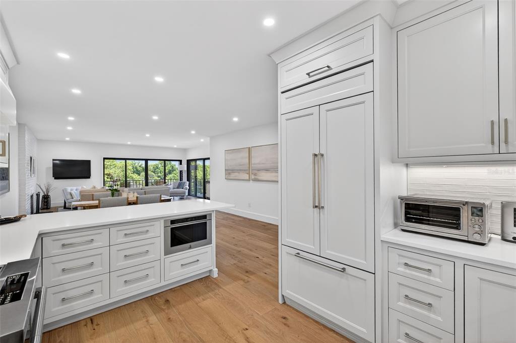 106 South Interlachen Avenue, Unit 518 Winter Park, FL 32789 - Photo 22 of 58 a kitchen with stainless steel appliances kitchen island granite countertop a refrigerator and a stove top oven