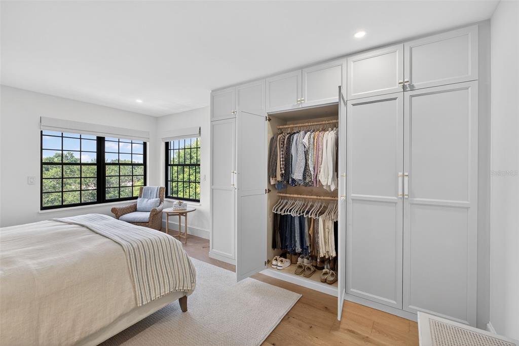 106 South Interlachen Avenue, Unit 518 Winter Park, FL 32789 - Photo 33 of 58 a bedroom with a bed a dresser and a large window