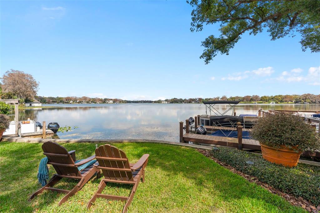 106 South Interlachen Avenue, Unit 518 Winter Park, FL 32789 - Photo 55 of 58 a view of a lake with table and chairs potted plants and a palm tree