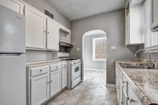 a kitchen with stainless steel appliances granite countertop a stove a sink and a microwave