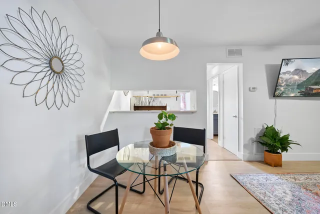 a dining room with furniture potted plants and wooden floor
