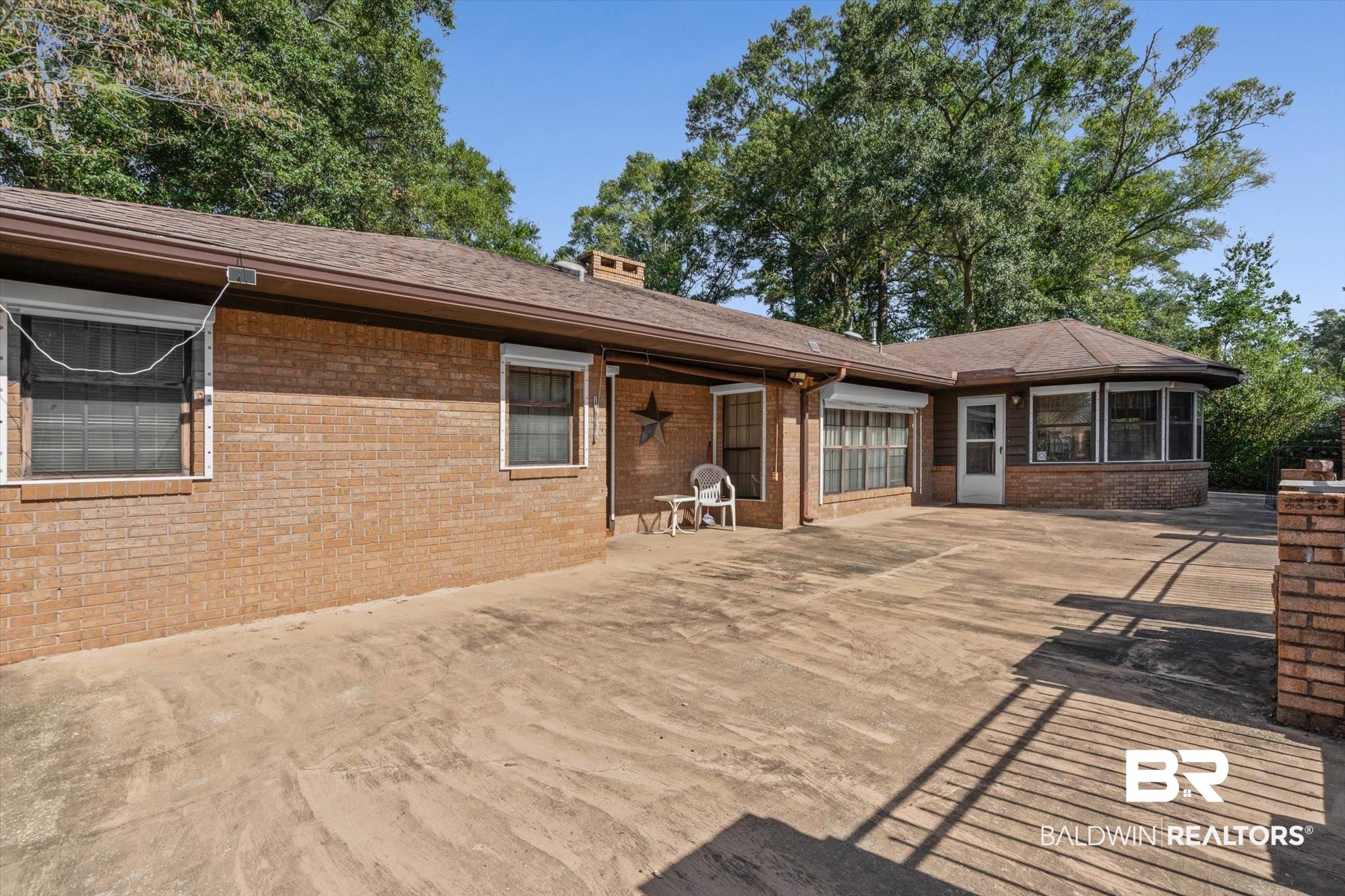 1900 Foxfire Road Mobile, AL 36618 - Photo 26 of 36 Rear view of property with a patio area, a sunroom, brick siding, and a chimney