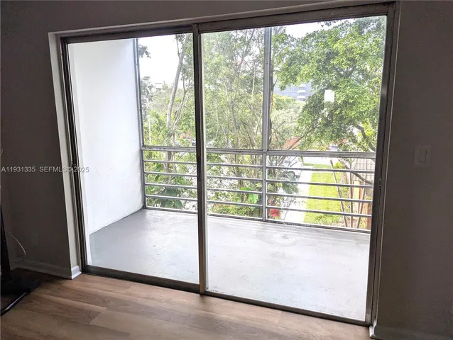 a view of empty room with wooden floor and front door