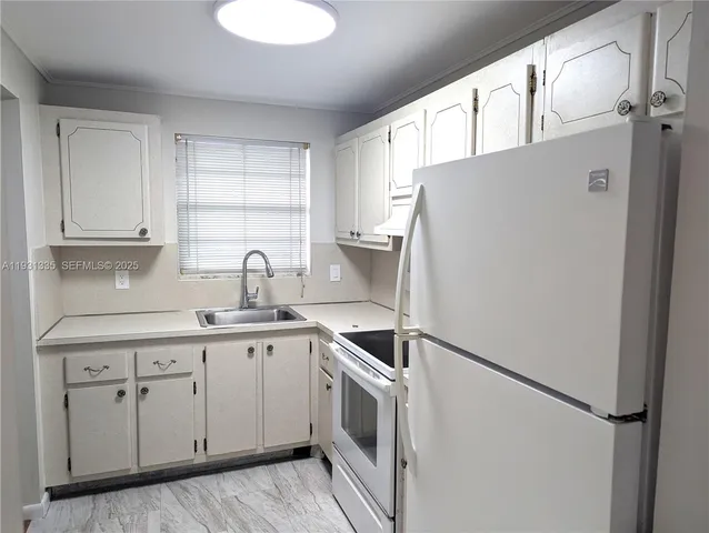 a kitchen with white cabinets and white appliances