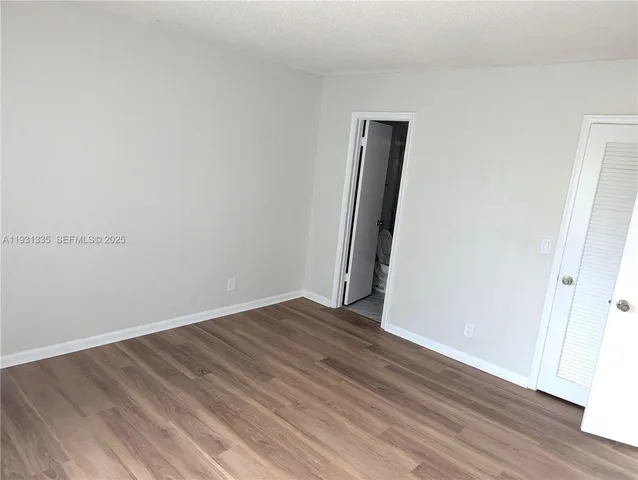 an empty room with wooden floor and closet
