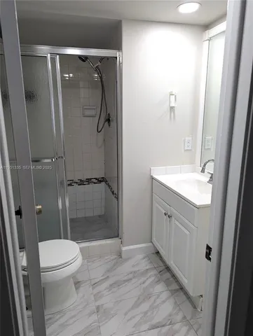 a bathroom with a granite countertop shower toilet and a sink
