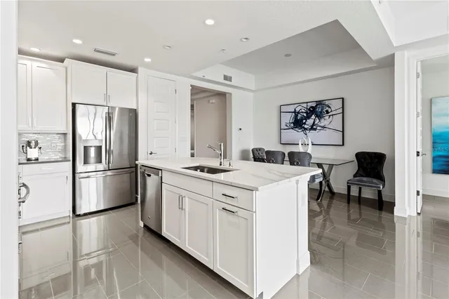 a kitchen with white cabinets and stainless steel appliances