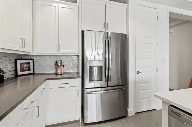 a kitchen with stainless steel appliances granite countertop a refrigerator and a stove top oven