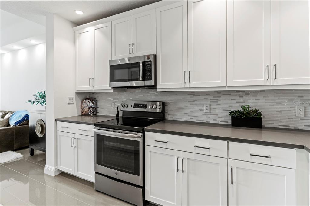 10520 Boardwalk Loop, Unit 302 Bradenton, FL 34202 - Photo 15 of 45 a kitchen with white cabinets and white appliances
