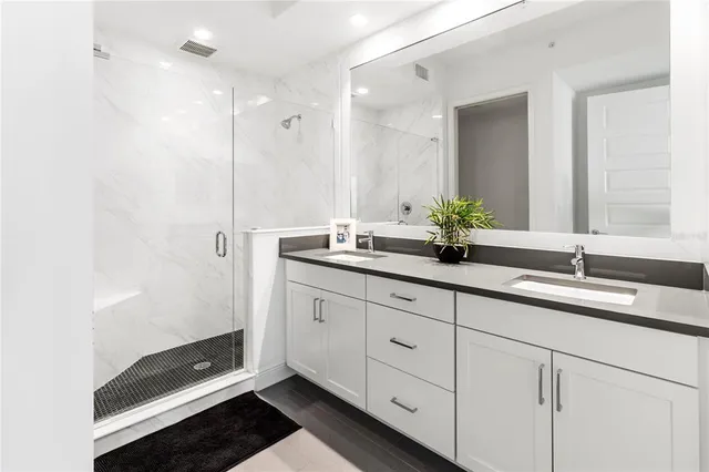 a bathroom with double sink and a mirror
