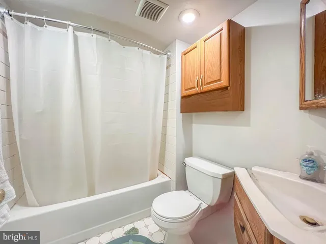 a white toilet sitting next to a bath tub