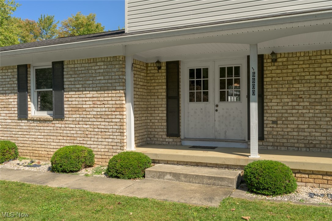 Doorway to property with brick siding