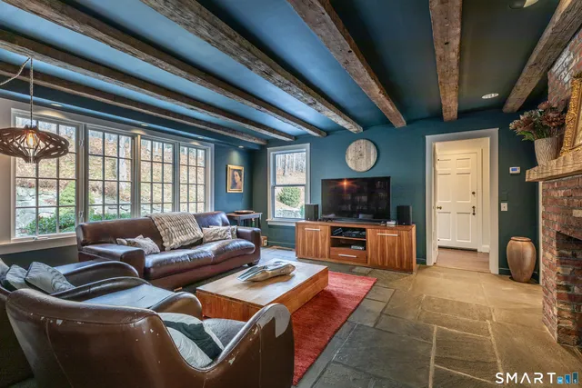 a living room with furniture a flat screen tv and a large window